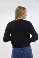 Sweater azul marino de punto con diseño de trenzas o espigas en relieve, cuello redondo y mangas largas con puños y dobladillo acanalados.