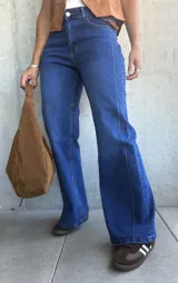 Jean de corte recto y tiro alto en color azul lavado, con costuras verticales decorativas en el frente y cierre frontal con botón metálico.