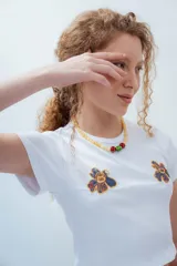 Remera gris de corte crop con estampado de una flor de estilo psicodélico.