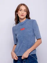 Remera verde oliva de manga corta y cuello alto, confeccionada en tejido waffle, con estampado rojo de la palabra "Tokyo" en el pecho.