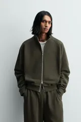 Sudadera de algodón con interior en rizo afelpado, cuello subido, manga larga y cierre frontal de cremallera. Presenta un efecto lavado que le da una apariencia única y bolsillos frontales ocultos en las costuras.