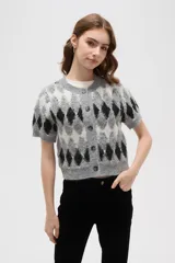 Cardigan de punto con diseño de rombos en tonos gris, blanco y negro. Presenta cuello redondo, cierre frontal con botones y mangas cortas.