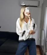 Blusa de tela cey color bordó, con escote en V y mangas largas abullonadas que terminan en puños con detalle de encaje y volados.