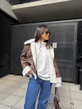 Campera tipo gamulán color marrón con interior y solapas de corderito sintético en color crema. Presenta cierre frontal, bolsillos laterales y diseño de corte holgado.