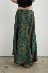 Falda larga irregular de seda con estampado en tonos marrón y verde, corte evasé y caída fluida.