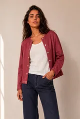 Chaqueta de lino color beige, de corte recto, escote redondo y cierre frontal con broches a presión. Cuenta con mangas largas y costuras decorativas pespunteadas en el frente.
