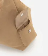 Cartera hobo mediana de Satinato, confeccionada en suede sintético de color tostado, con diseño suave y caída relajada. Cuenta con compartimento principal con cierre superior, bolsillos laterales con solapa, asa fija para el hombro y herrajes metálicos con acabado en níquel.