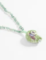 Collar de cuentas de piedra verde con dije de cerámica en forma de concha.