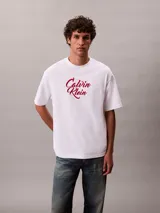 Remera Calvin Klein de corte relajado, confeccionada en algodón grueso blanco. Cuenta con cuello tipo mock y logo estampado en el pecho con tipografía cursiva en tono bordó.