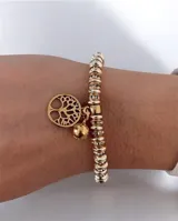 Pulsera elástica de cuentas metálicas doradas intercaladas con aros de strass, con dije colgante del árbol de la vida y una pequeña esfera lisa.