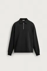 Sudadera polo de corte regular, confeccionada en tejido técnico interlock de algodón con elasticidad. Presenta cuello solapa, cierre frontal de cremallera y manga larga con puños acabados en rib.