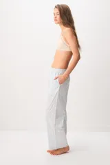 Pantalón largo tipo pijama de algodón, con diseño a rayas celestes y sutiles detalles de puntos rojos, corte recto y bolsillos laterales.