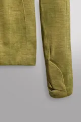 Camiseta térmica de manga larga ranglán, cuello redondo, color verde oliva con efecto tie-dye o jaspeado. Presenta tejido con lana, alta elasticidad y ajuste al cuerpo, con estructuras combinadas para facilitar la transpiración y sin costuras.