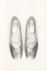 Chatas planas de cuero color plateado metálico, con punta cuadrada y un pequeño tacón bajo de madera.