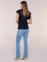 Blusa blanca de tejido calado estilo broderie con escote en V y mangas cortas tipo mariposa.