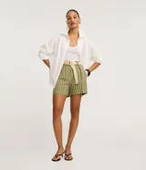 Short de viscosa y lino color verde militar con rayas verticales blancas, tiro alto, trabillas en la cintura y pinzas delanteras. Incluye cinturón de rafia beige con hebilla.