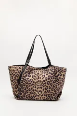 Cartera tipo shopper con estampado animal print, diseño amplio y flexible, con asas negras regulables y detalles metálicos.