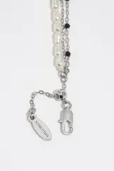 Pulsera multicapa de metal plateado con perlas, cuentas de vidrio multicolores y un dije colgante en forma de corazón con detalles esmaltados.