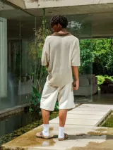 Chomba de tejido de punto abierto color crudo con cuello polo en color marrón chocolate.