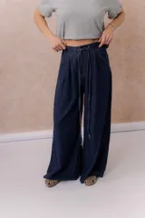 Jean de calce amplio y relajado, color azul, con pierna extra ancha y caída fluida. Diseño de tiro alto con pinzas delanteras y lazo regulable en la cintura. Cuenta con bolsillos laterales y traseros.