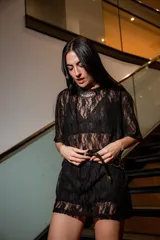 Remerón oversize de encaje negro con cuello redondo y mangas cortas.