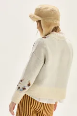 Sweater de cuello redondo con diseño de jacquard floral en cuerpo y mangas, confeccionado en tejido de punto con terminaciones acanaladas en puños y ruedo.