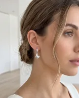 Aros tipo argolla de acero con incrustaciones de circonias y dije colgante en forma de mariposa.