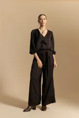 Pantalón ancho de tiro alto color marrón oscuro, con pinzas en la cintura, cinto incorporado y silueta fluida.