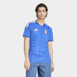 Camiseta de fútbol Adidas de manga corta para hombre, color azul con patrón geométrico en tono más oscuro. Presenta cuello en V con ribete dorado y detalles en los hombros con las tres franjas de Adidas en dorado. Incluye el escudo de la FIGC (Italia) en el pecho izquierdo y el logo de Adidas en el derecho.