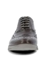 Zapato de cuero marrón tipo brogue con detalles perforados y cordones grises. Cuenta con suela de EVA y goma en tono gris claro.