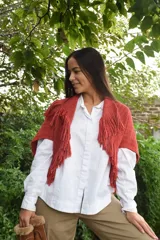 Capita artesanal de lana merino pura, color marrón con textura tejida y flecos decorativos en los bordes.