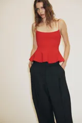 Top negro de escote redondo con tirantes muy finos y bajo acabado en peplum.