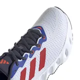 Championes de running Adidas Switch Run, con diseño moderno en color blanco, detalles en azul, rojo y gris oscuro. Presentan una entresuela de EVA con diseño de rebajes y suela Adiwear para mayor tracción.