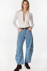 Jean de denim estilo slouchy o wide leg en color celeste, tiro medio y corte amplio, con costuras decorativas en las rodillas.