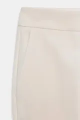 Pantalón de tiro alto con corte recto, bolsillos laterales y cierre frontal con cremallera y ganchos metálicos.