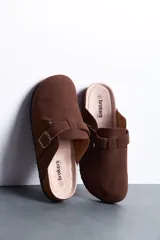 Sandalias estilo zueco de hombre, color marrón, con capellada cerrada, tira con hebilla ajustable lateral y suela de corcho y goma.