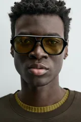 Sudadera de manga corta con cuello redondo, confeccionada en tejido texturizado de color verde oscuro/marrón. Presenta un corte relajado (relaxed fit).