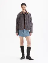 Minifalda de cuero ovino color azul, con terminación símil denim. Cuenta con bolsillos plaqué en la parte trasera y remaches tipo jeaneros. El acceso es mediante cierre y botón metálico.