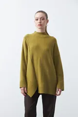 Polera de tejido de punto color marrón, con diseño asimétrico y costura diagonal frontal. Presenta cuello alto, hombros caídos, mangas largas con puños acanalados y ruedo con abertura frontal.