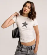 Remera de manga corta y cuello redondo, color blanco crudo, con un estampado central de estrella de cinco puntas con efecto desgastado o grunge.