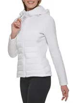 Campera ligera Calvin Klein con diseño de técnica mixta, que combina paneles acolchados en el frente con mangas y laterales lisos. Cuenta con cuello alto, capucha ajustable, cierre frontal de cremallera y bolsillos laterales invisibles.