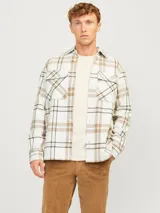 Sobrecamisa a cuadros color crema, marrón y blanco, de manga larga con cierre de botones y bolsillos en el pecho.