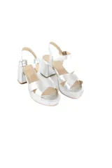 Sandalias plateadas con plataforma y taco cuadrado, tiras cruzadas sobre el empeine y pulsera con hebilla al tobillo.