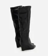Bota de caña alta Satinato en color negro, confeccionada en material sintético con acabado liso. Presenta un diseño de punta fina y tacón tipo anabela, con una estructura ajustada a la pierna.