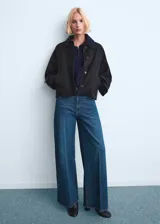 Pantalón de jean estilo wide leg con tiro alto, cinco bolsillos y cierre frontal de cremallera y botón.