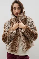 Campera corta de piel sintética en color crema, con cuello amplio tipo solapa y cierre frontal.