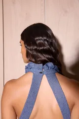 Vestido largo negro de crepe texturado con escote halter, cuello alto con volados y diseño holgado.