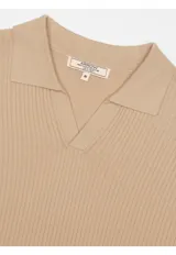 Remera tejida con cuello polo y escote en V, manga corta y diseño texturizado en canalé.