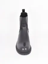 Bota tipo Chelsea de caña media, confeccionada en cuero sintético negro con paneles elásticos laterales y suela track dentada.