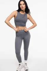 Top deportivo color gris oscuro, con escote a la base, copas removibles y largo a la cintura.
